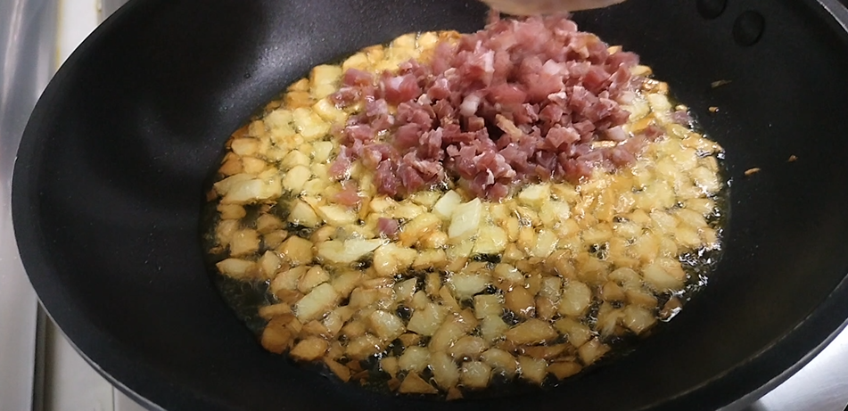Incorporar ajo y taquitos de jamón a la sartén